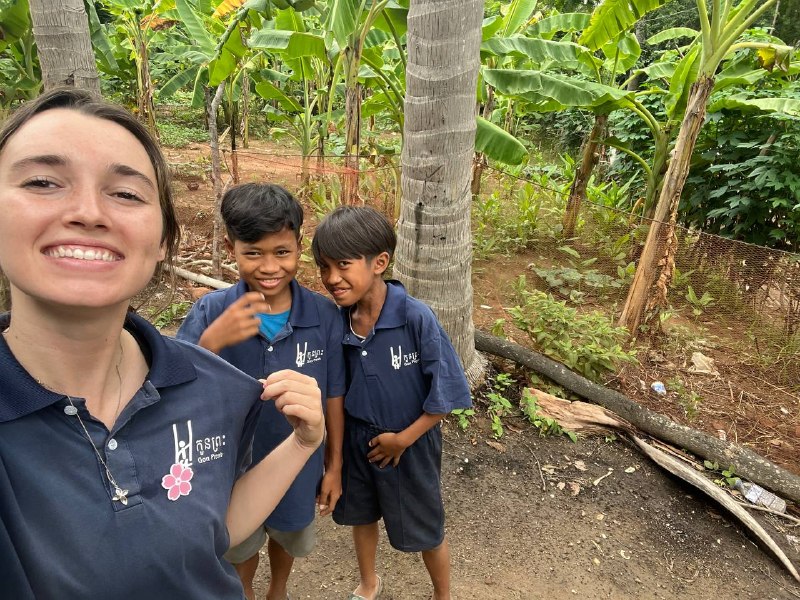 Brieya taking a selfie with two students from YDC in their school polos, laughing together outdoors.
