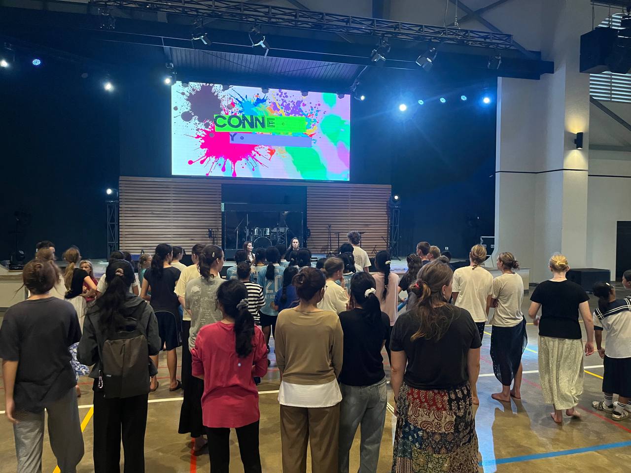 A crowd of youth gathered facing the stage during a youth service in Cambodia.