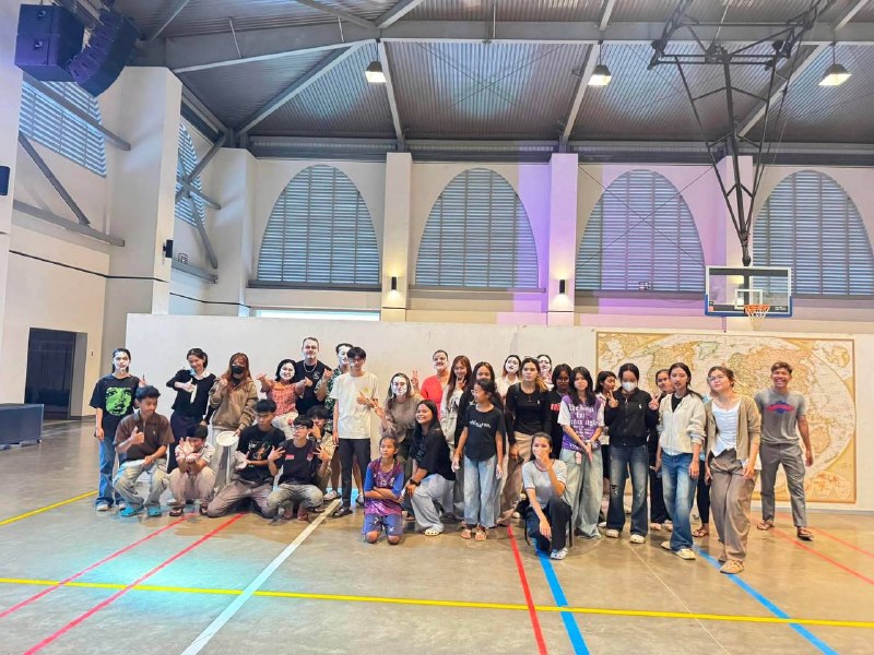 A large group of youth posing together in a gymnasium after a games event.